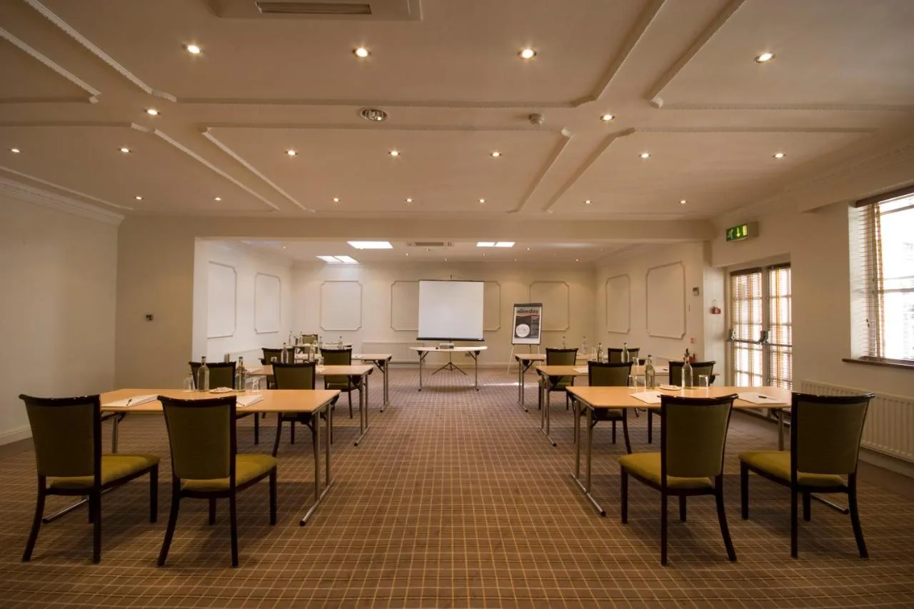 A conference room with tables and a whiteboard at Cotswold Lodge Hotel, North Oxford
