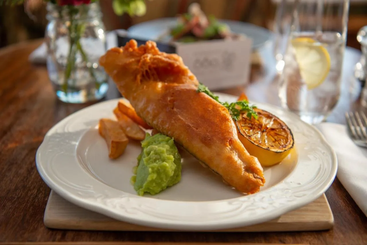 A fish dish on a white plate at Cotswold Lodge Hotel's restaurant